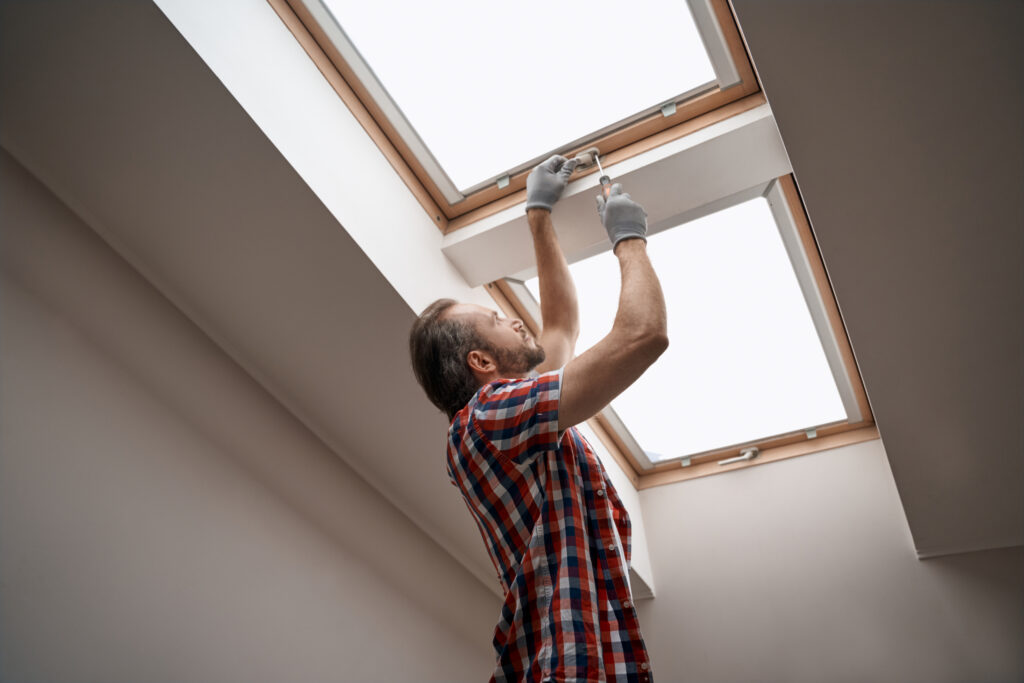 man fitting skylight window